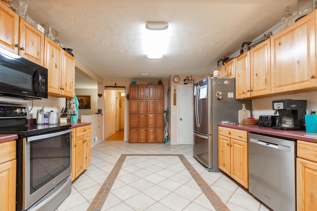2314 Hand Rd, Niles, MI 49120 - kitchen featuring appliances with stainless steel finishes, light brown cabinets, dark countertops, inlaid floor details, and a textured ceiling