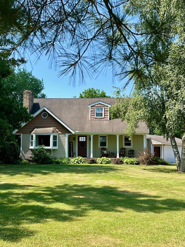 7220 W 64th St, Fremont, MI 49412 - view of front of home featuring a chimney, a garage, a front yard, and covered porch