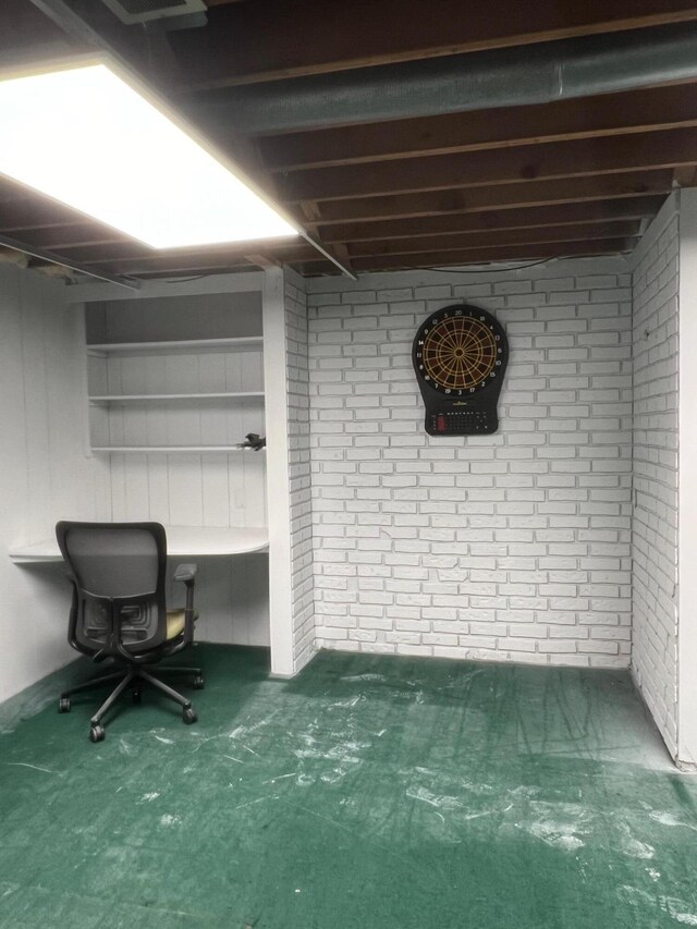 7220 W 64th St, Fremont, MI 49412 - below grade area with a desk, carpet floors, and brick wall