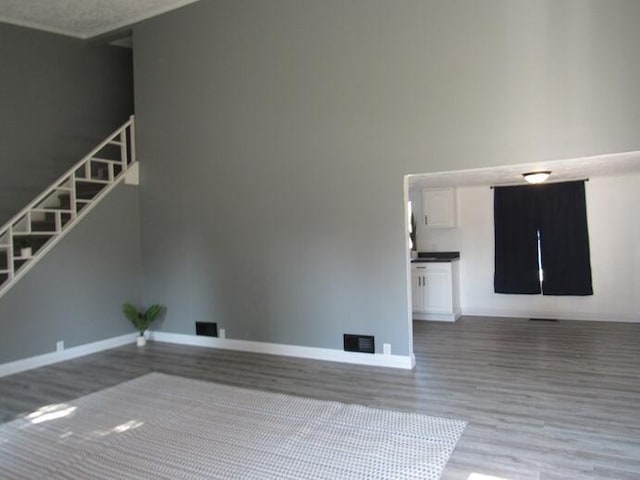 168 Fremont St, Bronson, MI 49028 - unfurnished living room featuring wood finished floors and stairs