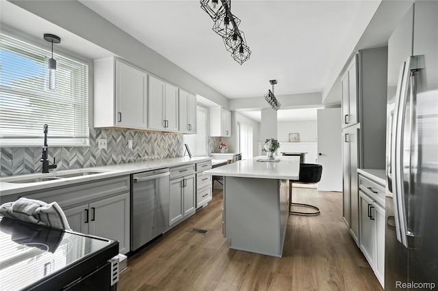 22679 Bell Brook St, Southfield, MI 48034 - kitchen featuring stainless steel appliances, a center island, backsplash, a breakfast bar area, and light countertops