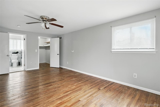 22679 Bell Brook St, Southfield, MI 48034 - unfurnished bedroom with wood finished floors, a walk in closet, connected bathroom, a closet, and a ceiling fan