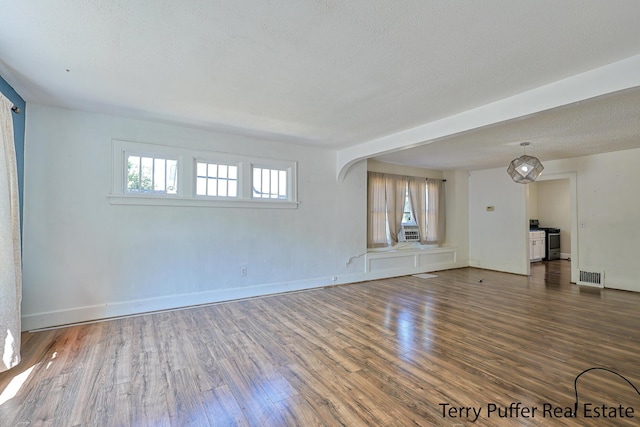 594 Oak Ave, Muskegon, MI 49442 - unfurnished living room featuring plenty of natural light, wood finished floors, and a textured ceiling