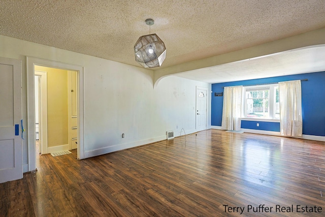 594 Oak Ave, Muskegon, MI 49442 - spare room with a textured ceiling, wood finished floors, and arched walkways