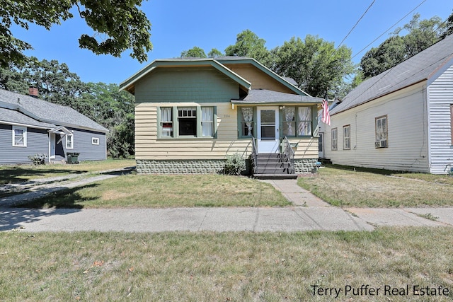 594 Oak Ave, Muskegon, MI 49442 - bungalow-style home featuring a front lawn