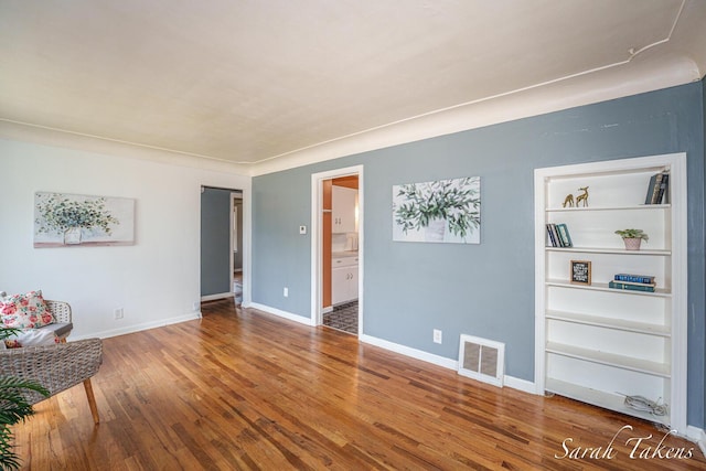 226 Elwell St SW, Grand Rapids, MI 49548 - unfurnished living room featuring wood finished floors and built in shelves