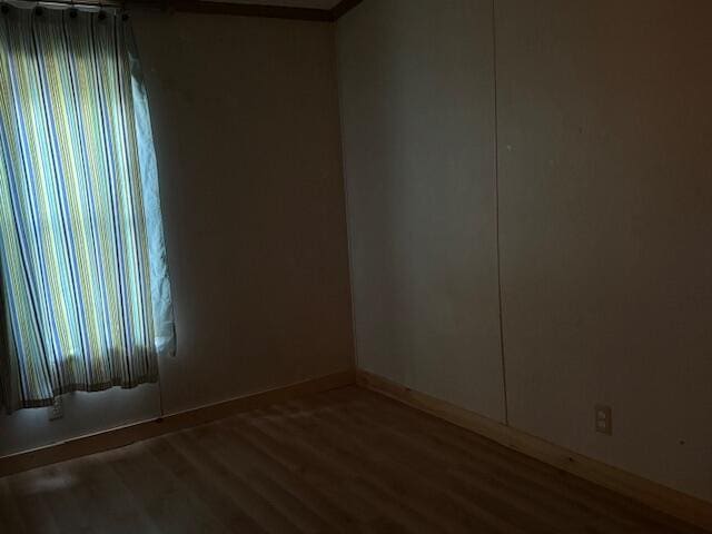 1422 E Monroe St, White Cloud, MI 49349 - empty room featuring wood finished floors and ornamental molding