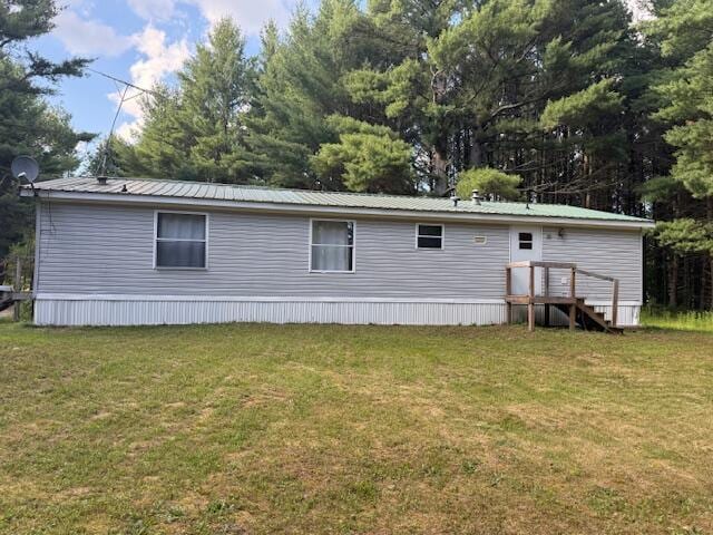 1422 E Monroe St, White Cloud, MI 49349 - rear view of house with a lawn and a metal roof