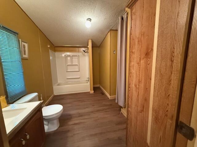 1422 E Monroe St, White Cloud, MI 49349 - bathroom with vanity, wood finished floors, a textured ceiling, and tub / shower combination