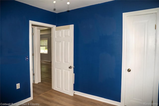 528 W Clinton St, Howell, MI 48843 - unfurnished bedroom featuring wood finished floors and baseboards