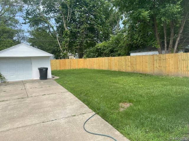 8645 Minock St, Detroit, MI 48228 - view of yard featuring a detached garage, an outdoor structure, and driveway