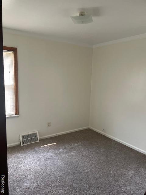 8645 Minock St, Detroit, MI 48228 - carpeted spare room with baseboards and crown molding