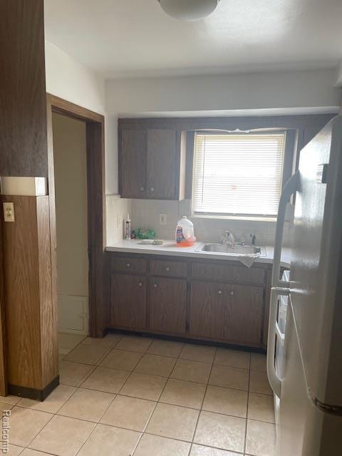 8645 Minock St, Detroit, MI 48228 - kitchen with freestanding refrigerator, light countertops, light tile patterned flooring, and dark brown cabinets