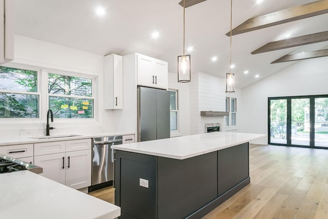 4046 Hillside Trl, New Buffalo, MI 49117 - kitchen featuring stainless steel appliances, beam ceiling, light wood-type flooring, white cabinets, and healthy amount of natural light