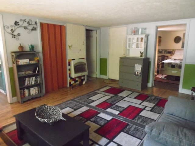 5294 Pinecrest, Prescott, MI 48756 - living area with heating unit, wood finished floors, and a textured ceiling