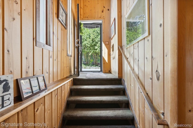 8641 Brettonwood Shores Rd, Rapid City, MI 49676 - stairs featuring healthy amount of natural light and wood walls