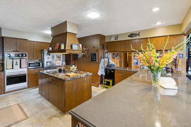 8641 Brettonwood Shores Rd, Rapid City, MI 49676 - kitchen featuring white double oven, stainless steel microwave, electric stovetop, stainless steel countertops, and a textured ceiling