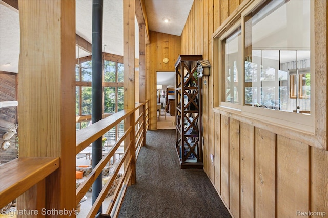 8641 Brettonwood Shores Rd, Rapid City, MI 49676 - hallway with dark colored carpet and wooden walls