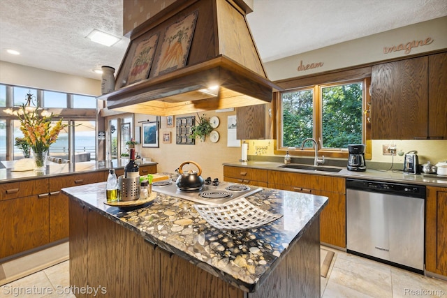 8641 Brettonwood Shores Rd, Rapid City, MI 49676 - kitchen with stainless steel appliances, a textured ceiling, a kitchen island, light tile patterned floors, and healthy amount of natural light