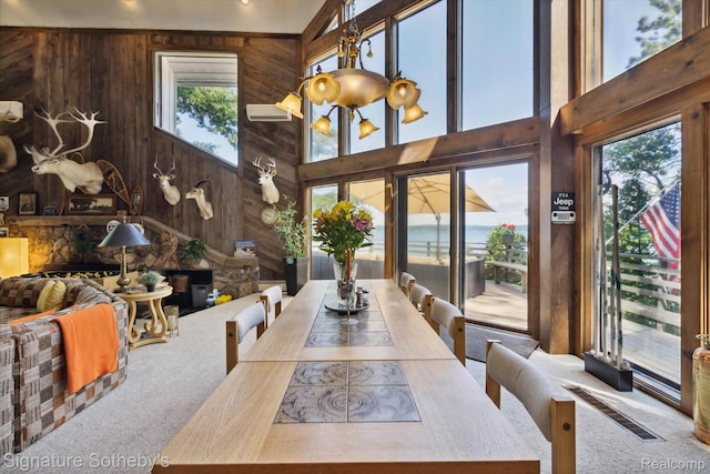 8641 Brettonwood Shores Rd, Rapid City, MI 49676 - dining space featuring wood walls, carpet, and a high ceiling