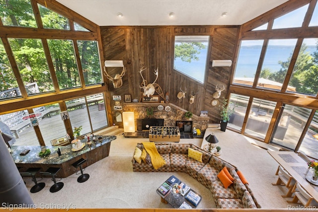8641 Brettonwood Shores Rd, Rapid City, MI 49676 - living area featuring carpet, a stone fireplace, wooden walls, and a towering ceiling