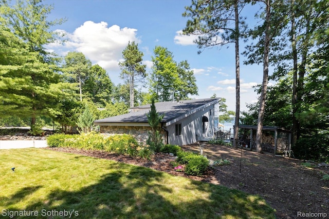 8641 Brettonwood Shores Rd, Rapid City, MI 49676 - view of side of property featuring a lawn and stone siding