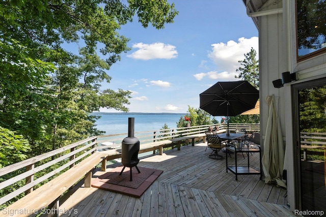 8641 Brettonwood Shores Rd, Rapid City, MI 49676 - wooden deck with a water view and outdoor dining area