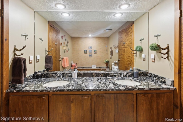 8641 Brettonwood Shores Rd, Rapid City, MI 49676 - full bath with double vanity, a textured ceiling, and a garden tub