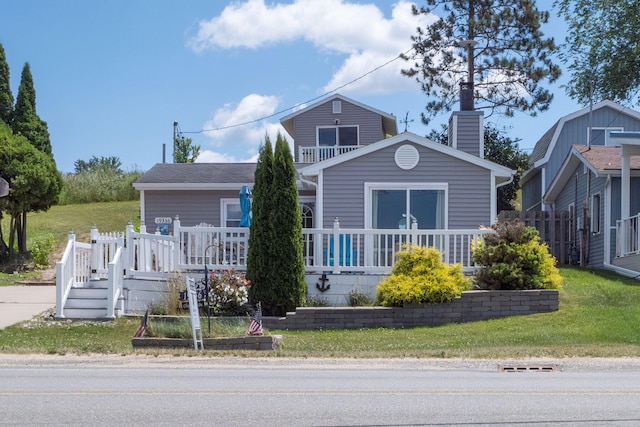 19336 E Chippewa Dr, Chippewa Lake, MI 49320 - view of front facade featuring a chimney, a front yard, and a wooden deck
