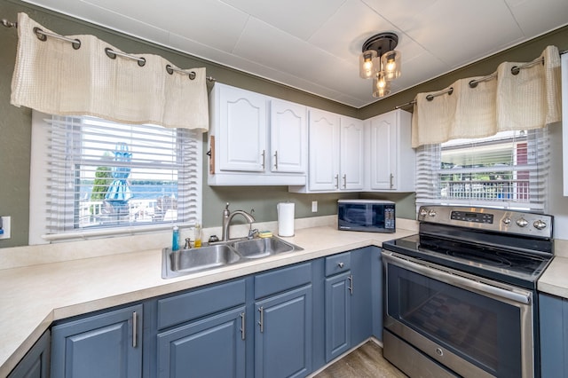 19336 E Chippewa Dr, Chippewa Lake, MI 49320 - kitchen featuring stainless steel range with electric cooktop, blue cabinetry, white cabinetry, and light countertops