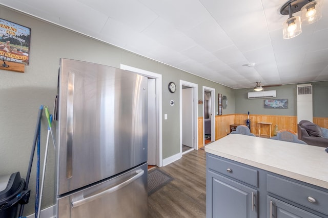 19336 E Chippewa Dr, Chippewa Lake, MI 49320 - kitchen featuring freestanding refrigerator, an AC wall unit, gray cabinets, dark wood finished floors, and light countertops