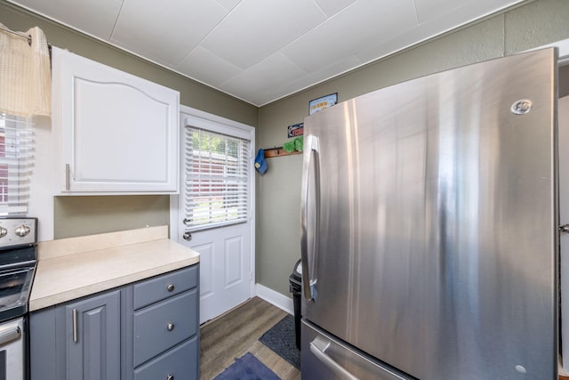 19336 E Chippewa Dr, Chippewa Lake, MI 49320 - kitchen with freestanding refrigerator, dark wood-type flooring, white cabinetry, stove, and light countertops