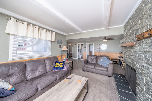 19336 E Chippewa Dr, Chippewa Lake, MI 49320 - carpeted living room featuring beamed ceiling, a large fireplace, wainscoting, ceiling fan, and tile patterned floors
