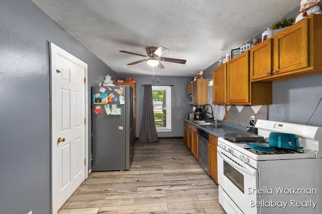 803 S Hanover St, Hastings, MI 49058 - kitchen with appliances with stainless steel finishes, a textured ceiling, ceiling fan, light wood-style floors, and brown cabinets