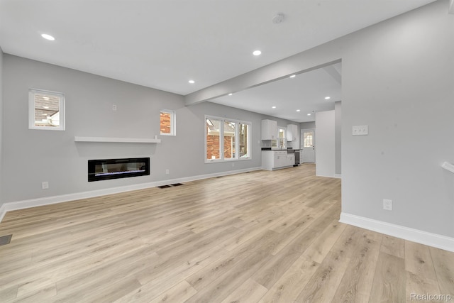 5291 Devonshire Rd, Detroit, MI 48224 - unfurnished living room featuring light wood-style floors, recessed lighting, and a glass covered fireplace