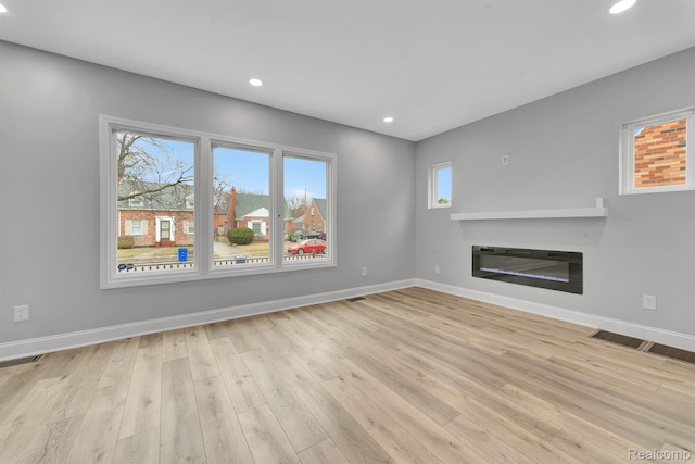 5291 Devonshire Rd, Detroit, MI 48224 - unfurnished living room featuring a glass covered fireplace, wood finished floors, and recessed lighting