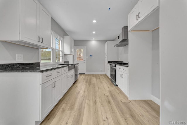 5291 Devonshire Rd, Detroit, MI 48224 - kitchen with stainless steel appliances, wall chimney range hood, white cabinetry, light wood-style flooring, and recessed lighting