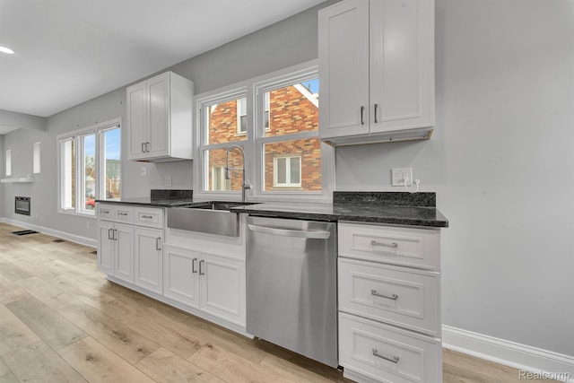 5291 Devonshire Rd, Detroit, MI 48224 - kitchen with stainless steel dishwasher, light wood-style floors, and white cabinets