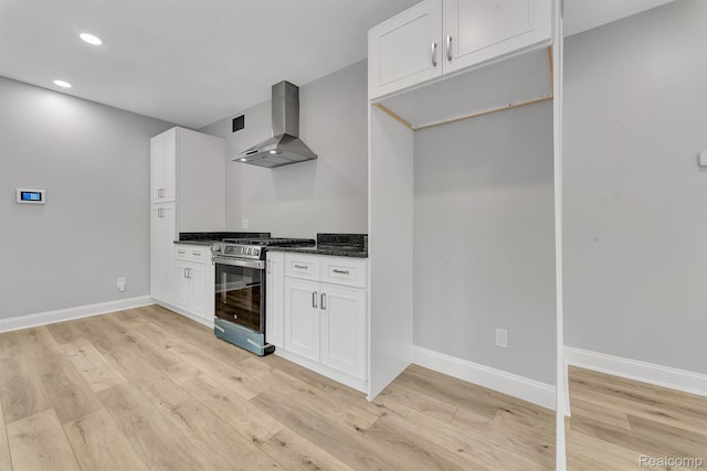 5291 Devonshire Rd, Detroit, MI 48224 - kitchen featuring wall chimney range hood, gas stove, light wood-type flooring, recessed lighting, and white cabinetry