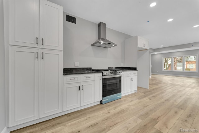 5291 Devonshire Rd, Detroit, MI 48224 - kitchen with stainless steel range oven, wall chimney range hood, light wood-style floors, white cabinets, and recessed lighting