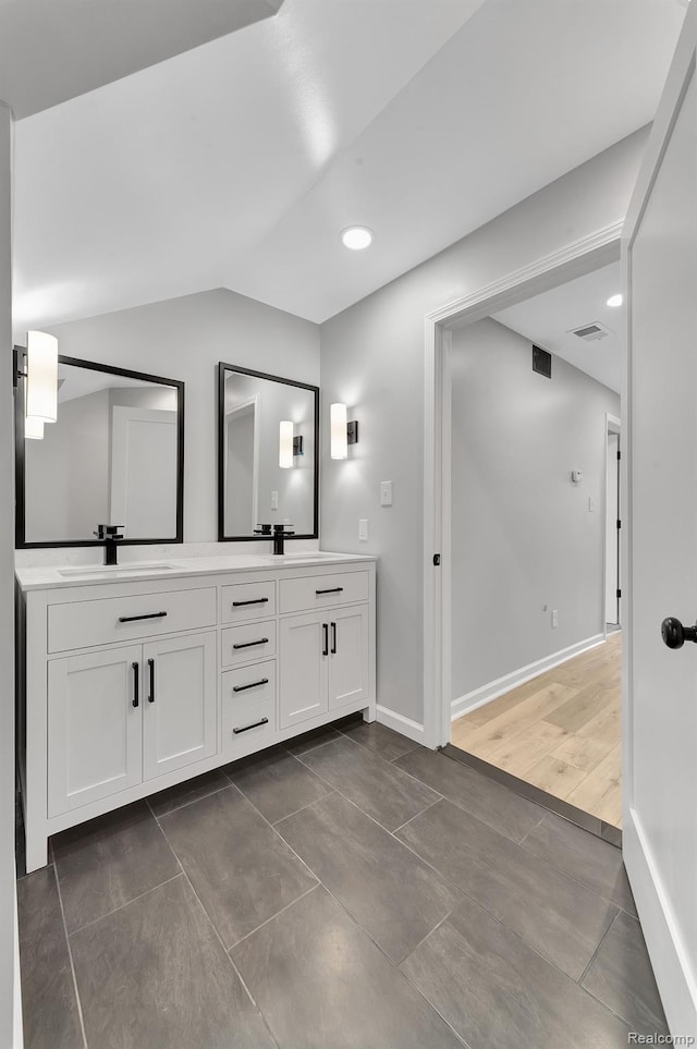 5291 Devonshire Rd, Detroit, MI 48224 - full bath with double vanity, vaulted ceiling, and tile patterned flooring