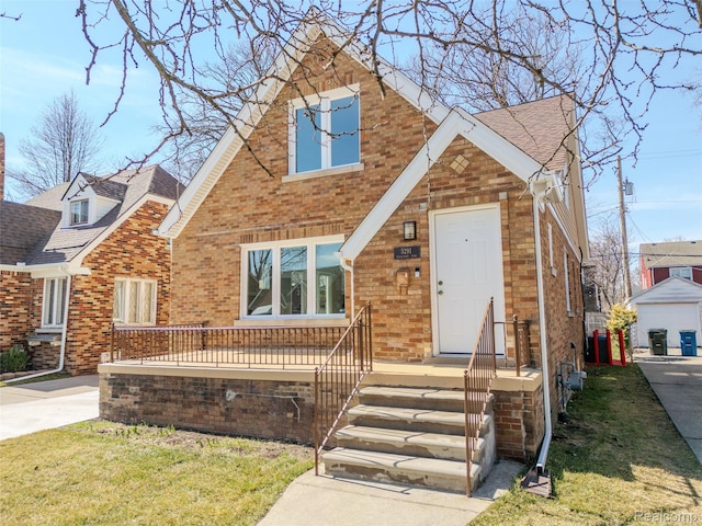 5291 Devonshire Rd, Detroit, MI 48224 - view of front of house featuring brick siding, a front yard, and a shingled roof