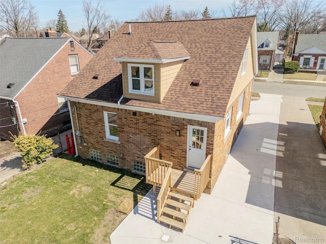 5291 Devonshire Rd, Detroit, MI 48224 - view of front of home with a shingled roof, brick siding, and a front lawn