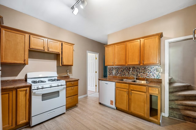 920 Wisconsin Ave, Saint Joseph, MI 49085 - kitchen featuring white appliances, light wood-style flooring, tasteful backsplash, dark countertops, and brown cabinetry
