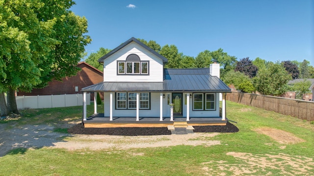 210 W Grove Ave, Michigan Center, MI 49254 - view of front facade featuring a chimney, covered porch, and a metal roof