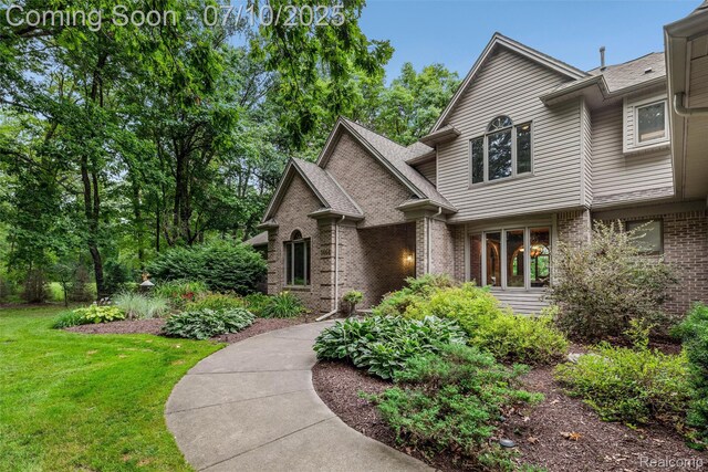 1444 W Clarkston Rd, Lake Orion, MI 48362 - view of front facade featuring brick siding and a front lawn