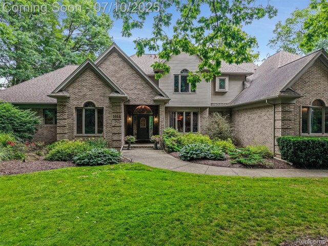 1444 W Clarkston Rd, Lake Orion, MI 48362 - traditional-style home with brick siding, a front yard, and a shingled roof