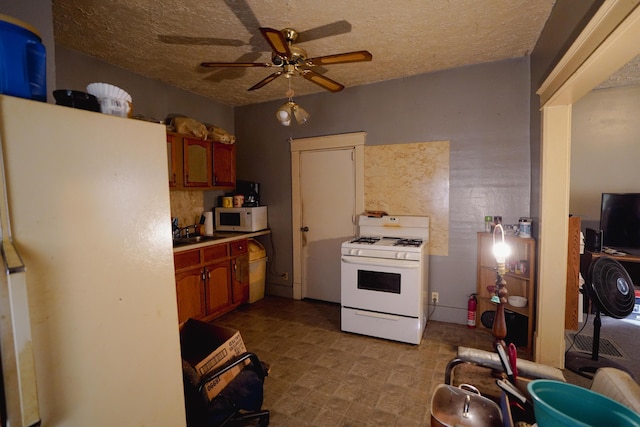 57 S 3rd St, Niles, MI 49120 - kitchen featuring white appliances, a ceiling fan, a textured ceiling, light countertops, and brown cabinetry
