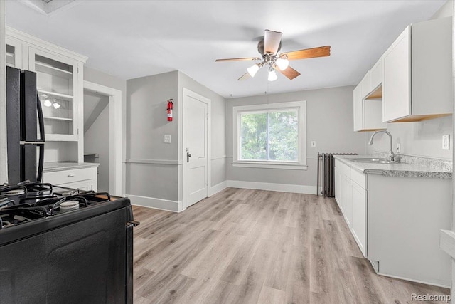 922 Maple, Wyandotte, MI 48192 - kitchen featuring black appliances, a ceiling fan, light countertops, light wood-style flooring, and white cabinets