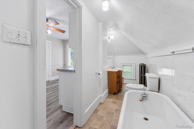 922 Maple, Wyandotte, MI 48192 - bathroom featuring a freestanding tub, vanity, a textured ceiling, a ceiling fan, and lofted ceiling